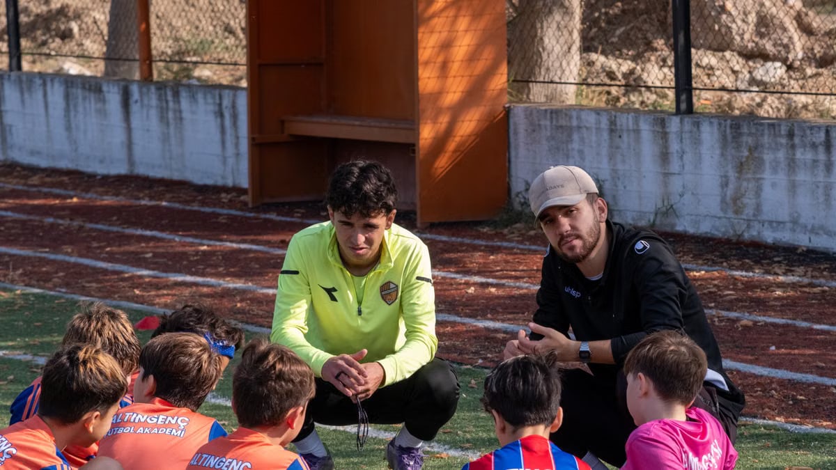 Youth soccer team huddles with coaches for strategy during practice in Izmir, Turkey.